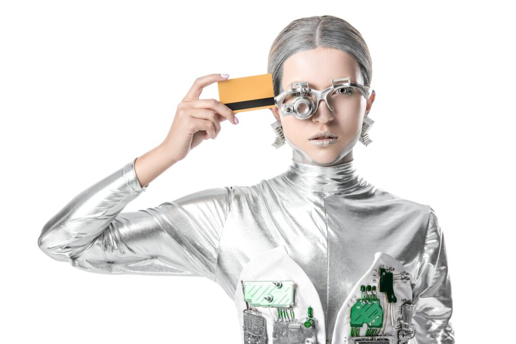 silver robot touching head with credit card isolated on white, future technology concept