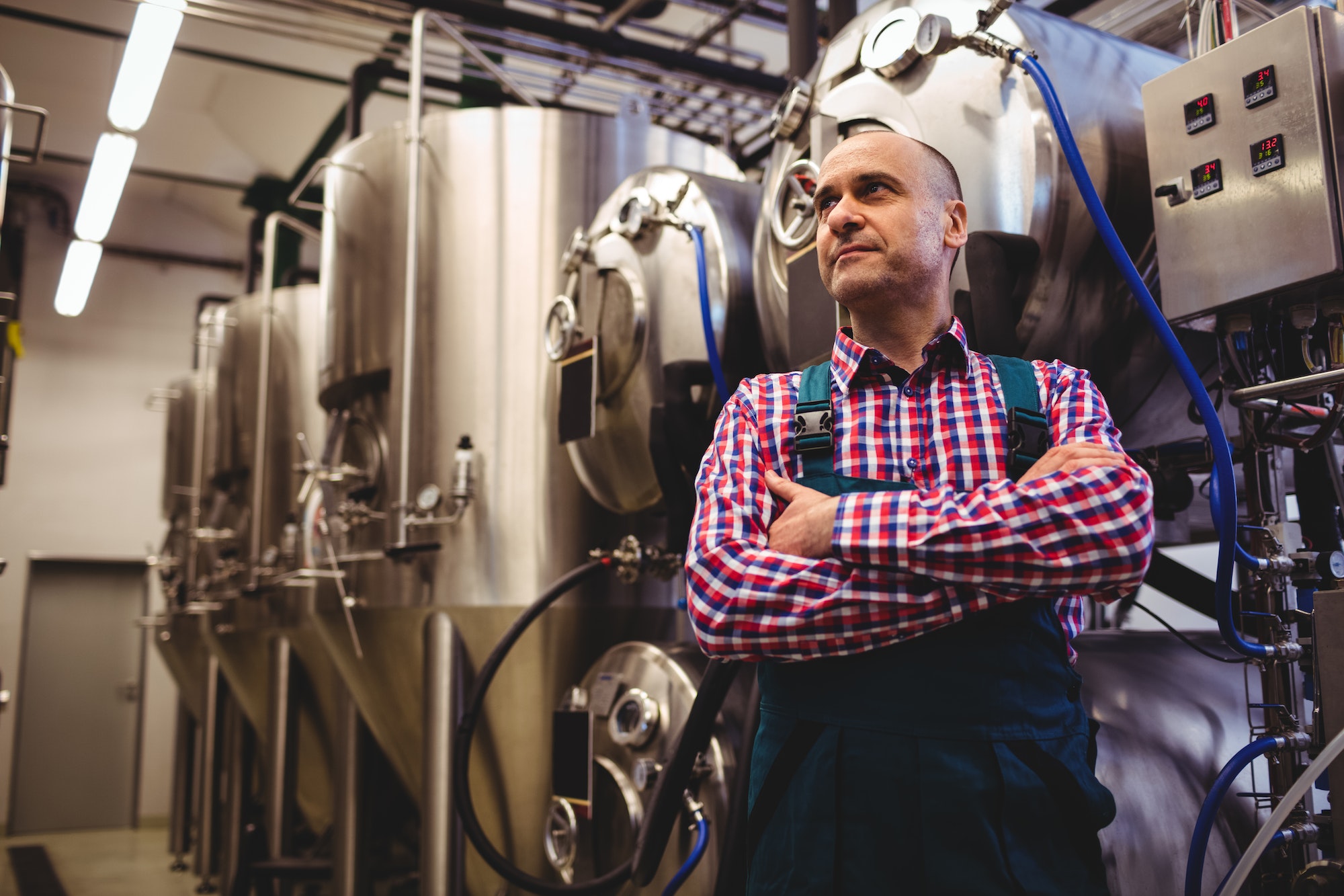 Brewery manufacturer standing by storage tank